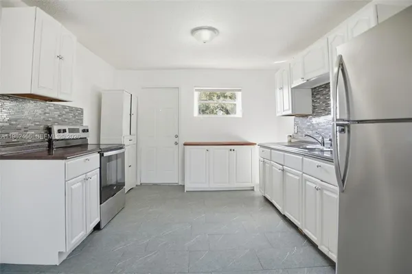 a kitchen with white cabinets and white appliances