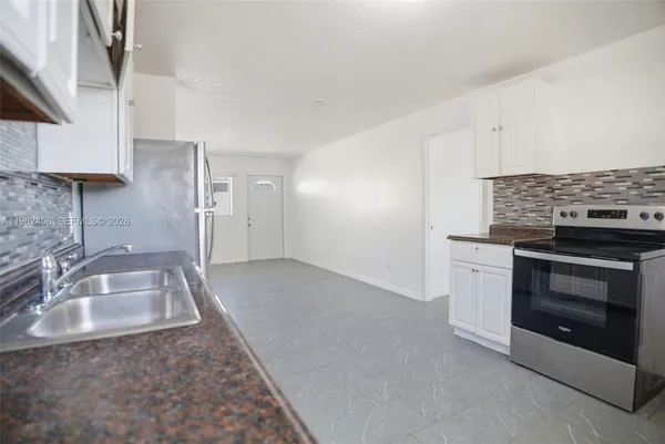 a kitchen with granite countertop a sink stainless steel appliances and cabinets
