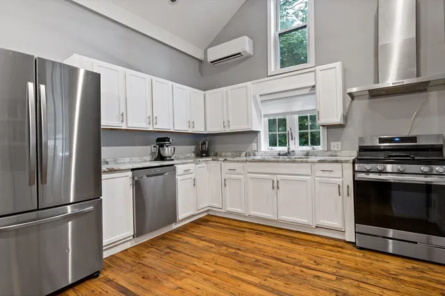 a kitchen with stainless steel appliances granite countertop a stove a sink and a refrigerator