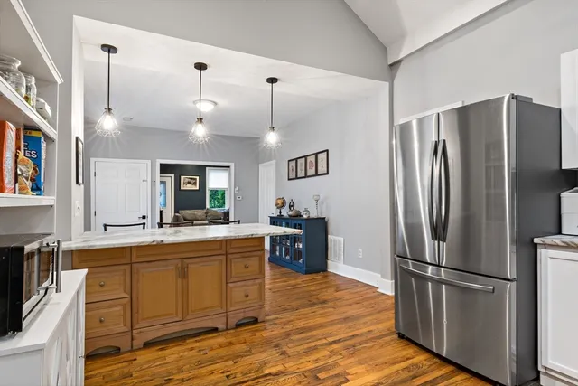 a kitchen with kitchen island a counter top space wooden floor and stainless steel appliances