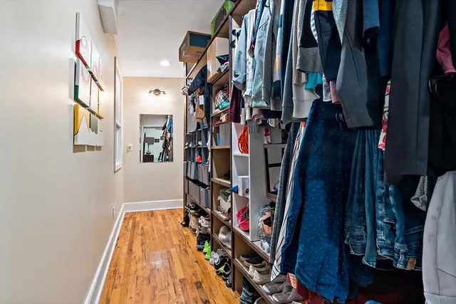 a view of walk in closet with clothes