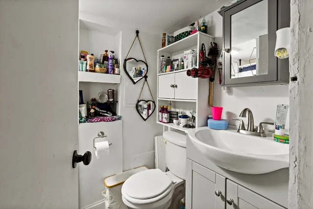 a bathroom with a sink vanity mirror and toilet