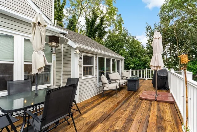 a balcony with wooden floor table and chairs