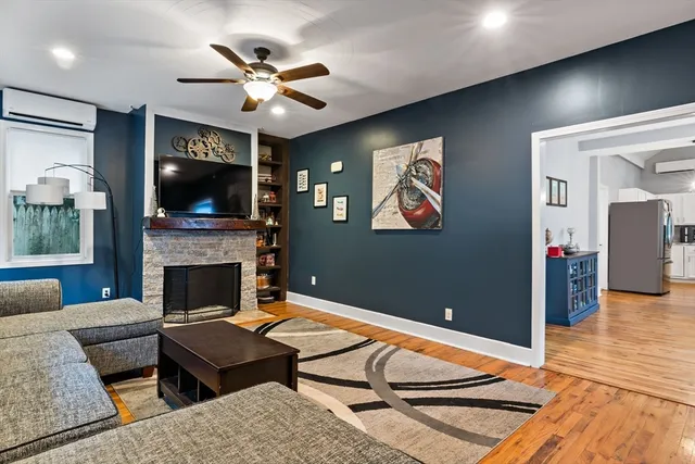 a living room with furniture a flat screen tv and a fireplace