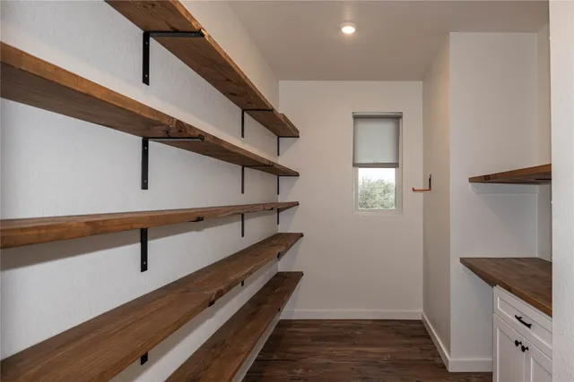 a hallway with wooden floor and staircase