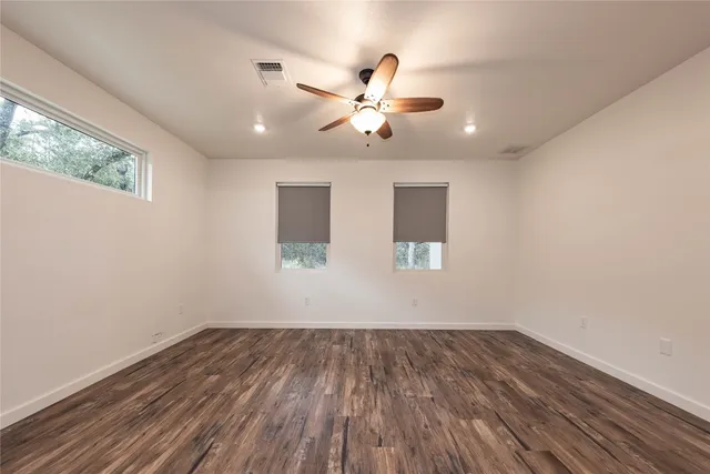 a view of a room with wooden floor and ceiling fan