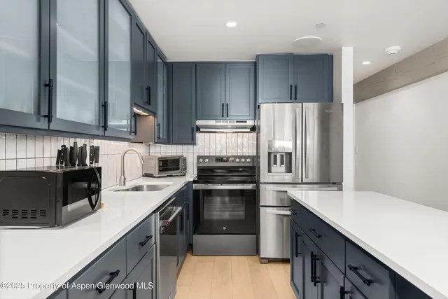 a kitchen with a sink appliances and cabinets