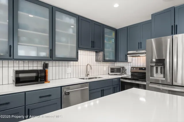 a kitchen with stainless steel appliances a stove sink microwave and cabinets