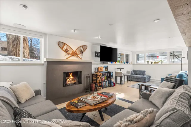 a living room with furniture a fireplace and a flat screen tv