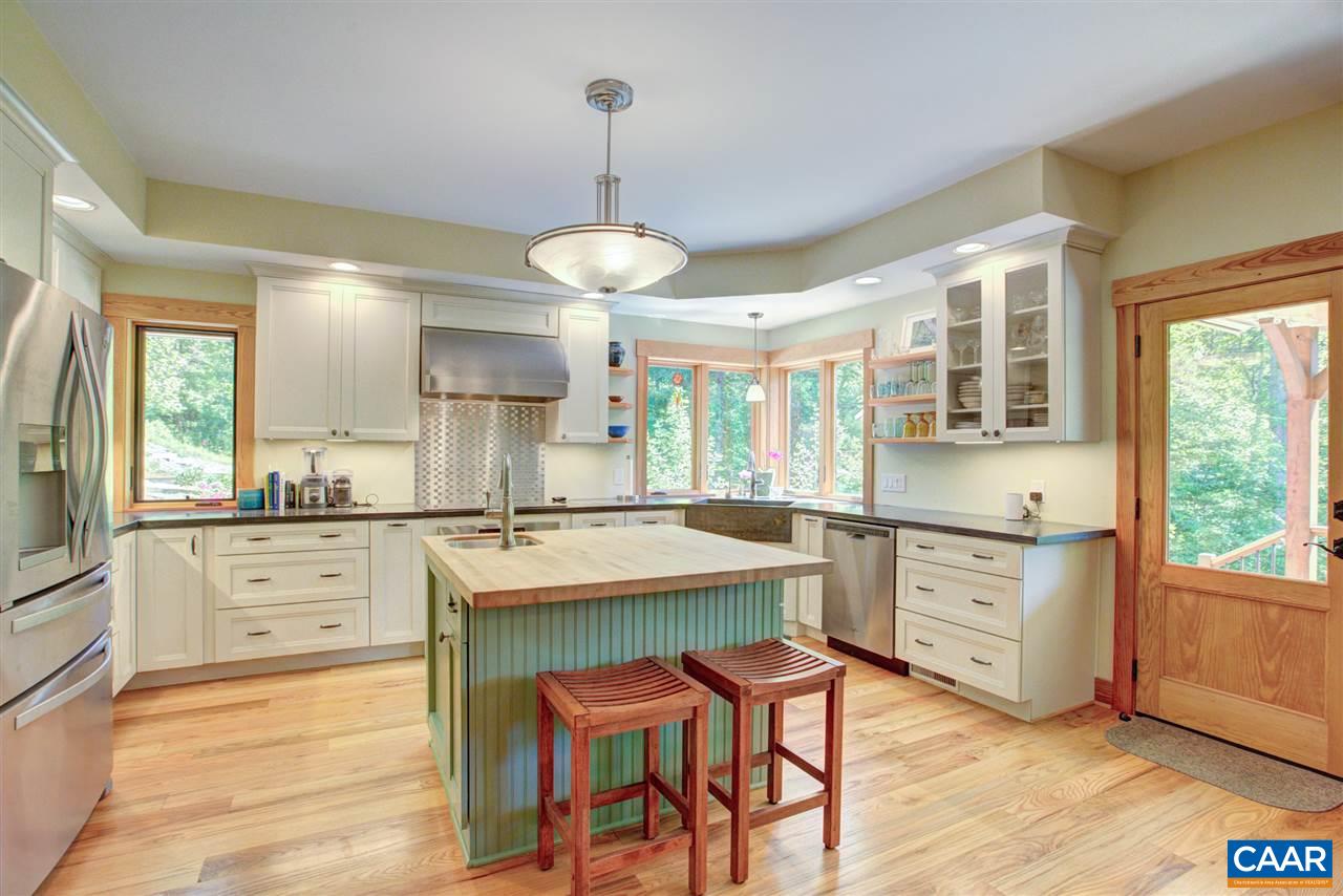 100 Miller School Road Charlottesville, VA 22903 - Photo 14 of 47 a kitchen with white cabinets stainless steel appliances dining table and a large window