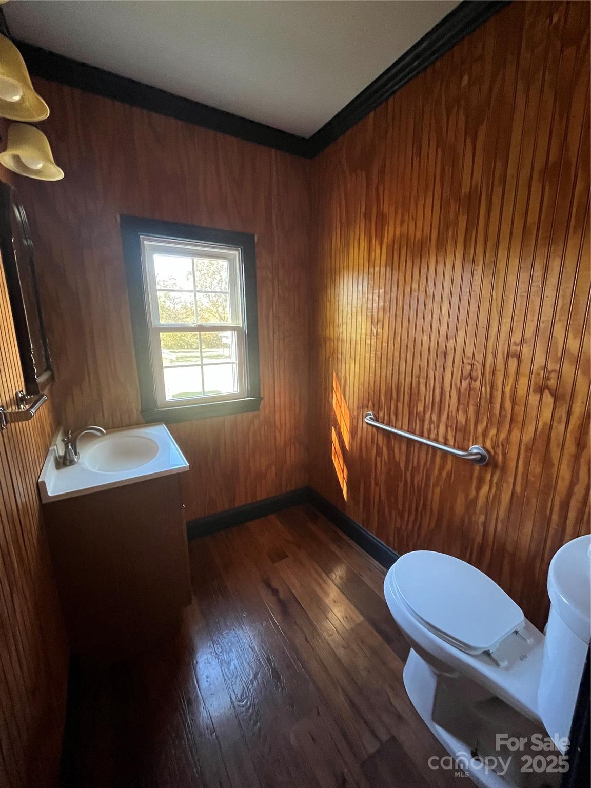 9404 Providence Road South Waxhaw, NC 28173 - Photo 40 of 45 a bathroom with a toilet a sink a mirror and wooden floor