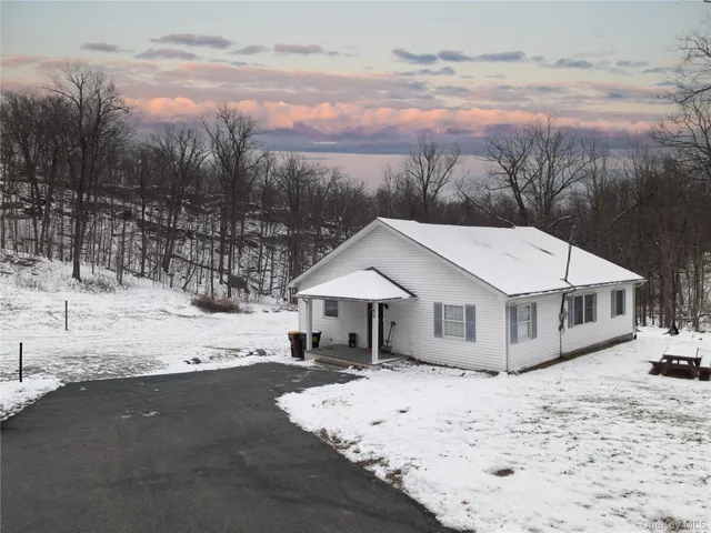 a view of a house with a yard covered in snow