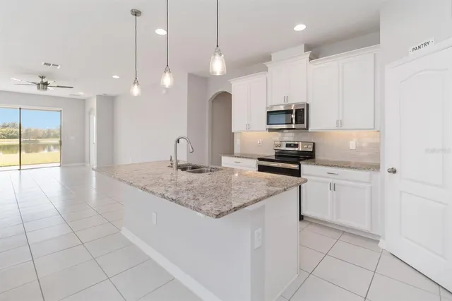 a kitchen with a sink a counter top space cabinets and stainless steel appliances