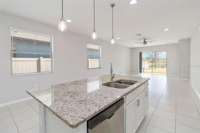 a kitchen with granite countertop kitchen island a sink stainless steel appliances and a counter space