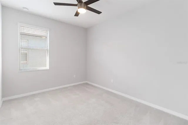 an empty room with a window and a fan