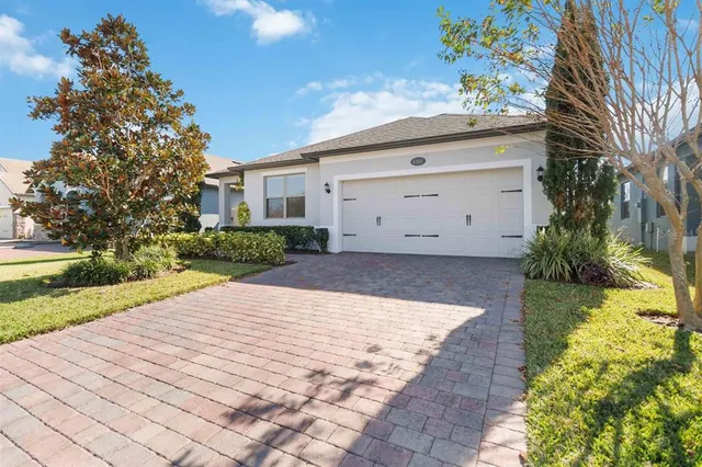 a view of a white house with a yard and potted plants