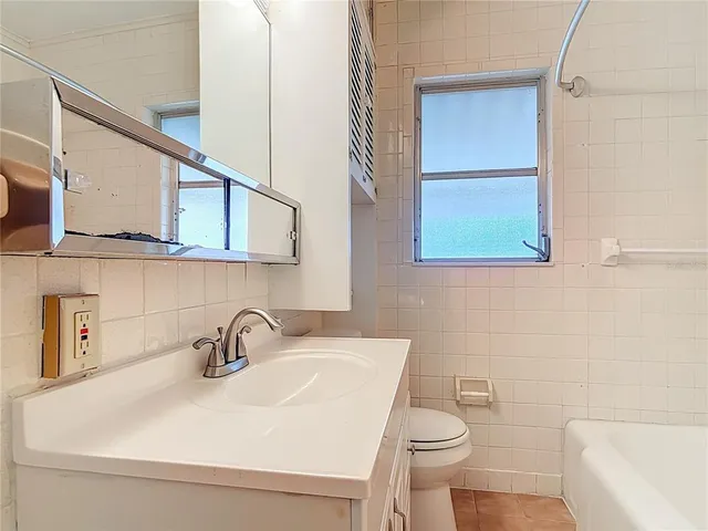 a bathroom with a sink a toilet and mirror