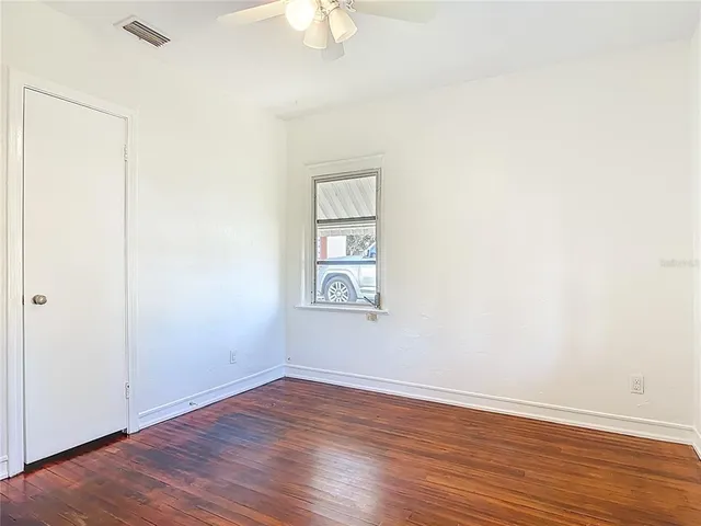 an empty room with wooden floor and window