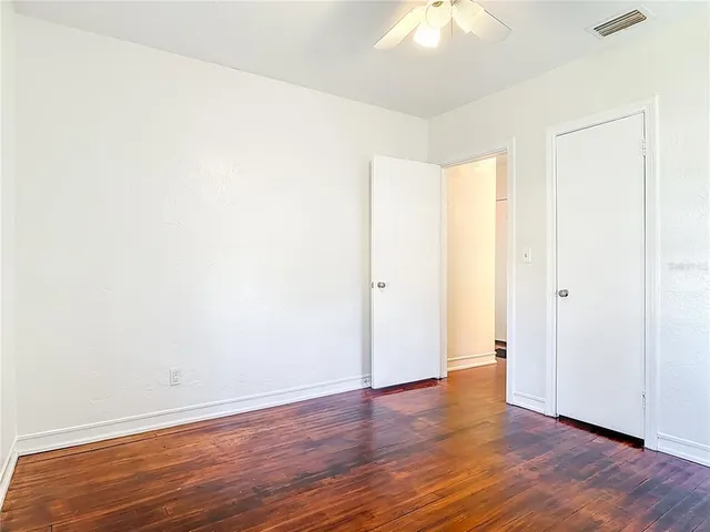 a view of an empty room with wooden floor