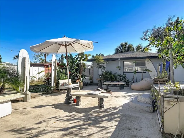 a view of a patio with table and chairs under an umbrella