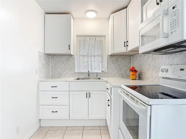 a kitchen with cabinets appliances a sink and a counter space