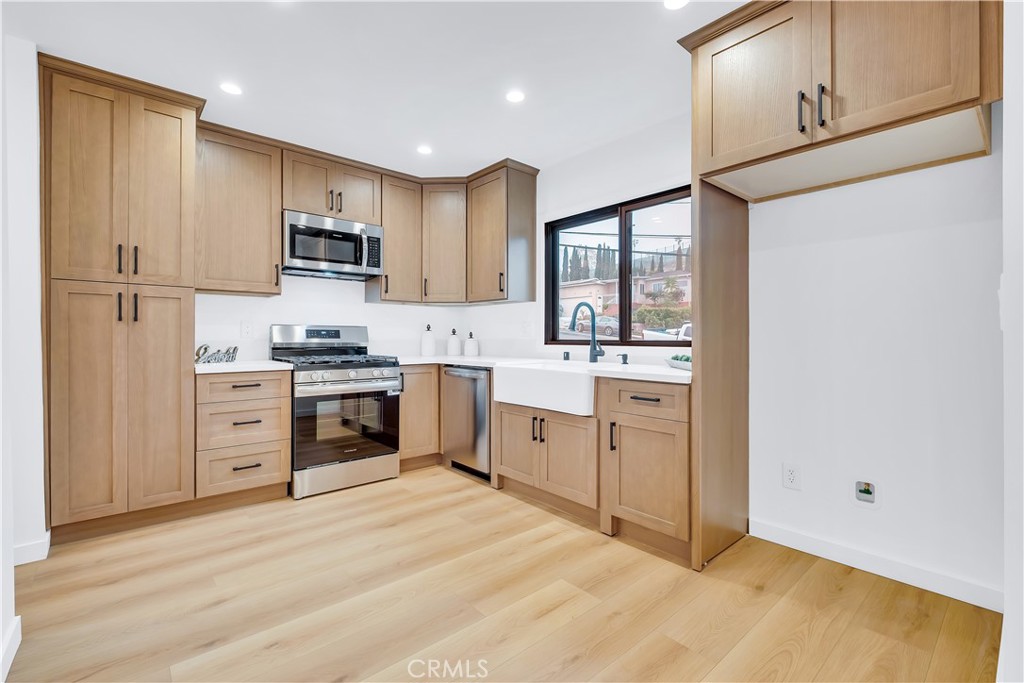 25710 Crest Road Torrance, CA 90505 - Photo 25 of 72 This stunning remodeled kitchen seamlessly combines modern elegance with timeless design. Bright, open & inviting. It features custom cabinets, soft closing drawers, sleek quartz countertops with Farmhouse sink, new faucet & new stainless steel appliances.