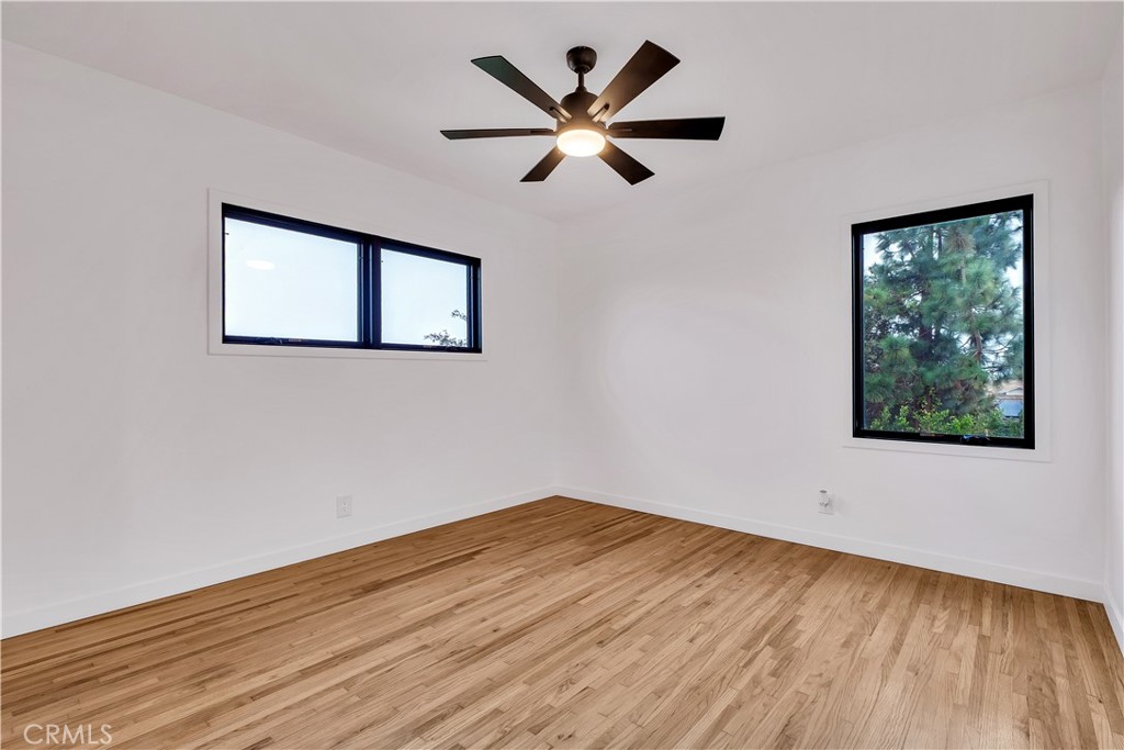 25710 Crest Road Torrance, CA 90505 - Photo 30 of 70 Rear Primary Bedroom #1 with views, refinished original hardwood floors, new baseboards, 2 new windows & new ceiling fan.