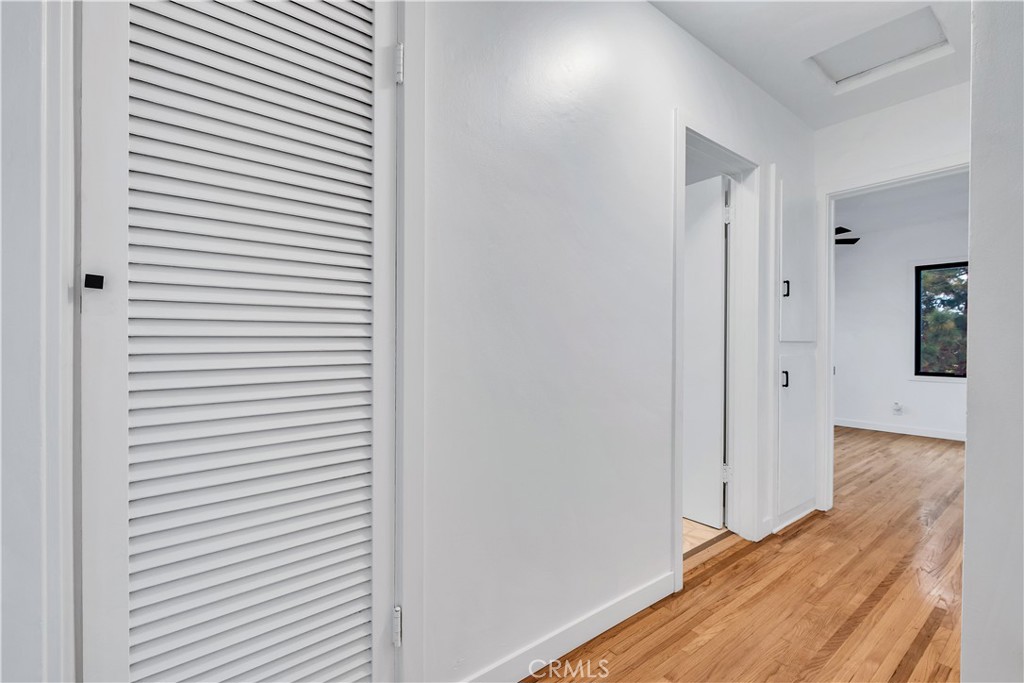 25710 Crest Road Torrance, CA 90505 - Photo 33 of 72 Hall view of linen closets, Full Bathroom entrance door & Rear Primary Bedroom with refinished original hardwood floors.