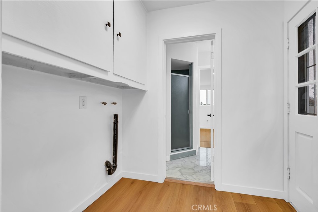 25710 Crest Road Torrance, CA 90505 - Photo 52 of 72 Inside Laundry Room with exterior exit door to side yard, new luxury laminated flooring, new base boards & new ceiling light fixture is located between the 3/4 bathroom & the new remodeled kitchen.