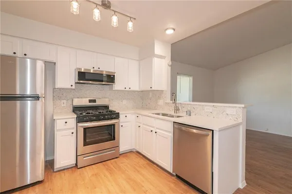 a kitchen with a stove a sink and a refrigerator