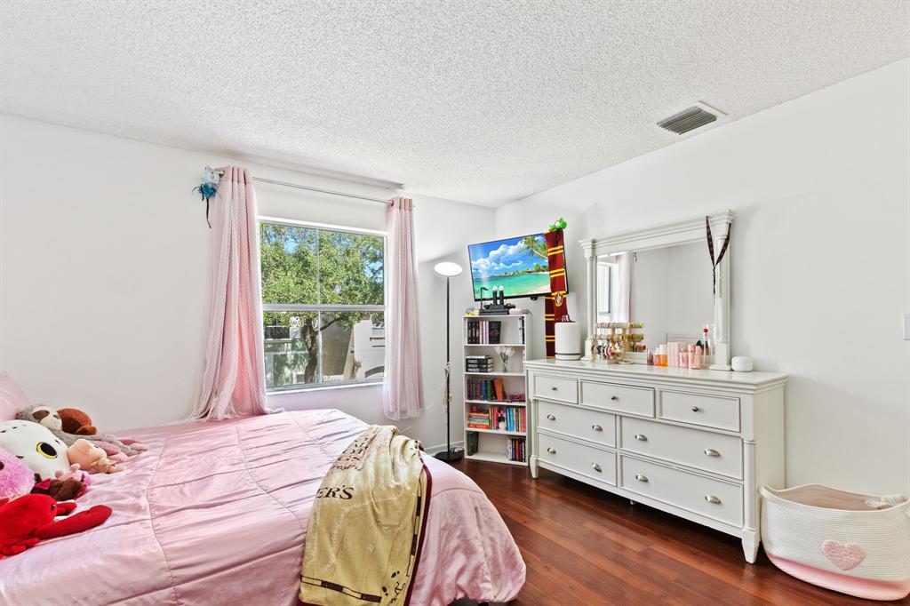 4035 Tree Top Road Cooper City, FL 33026 - Photo 18 of 33 a bedroom with a bed and a dresser in it