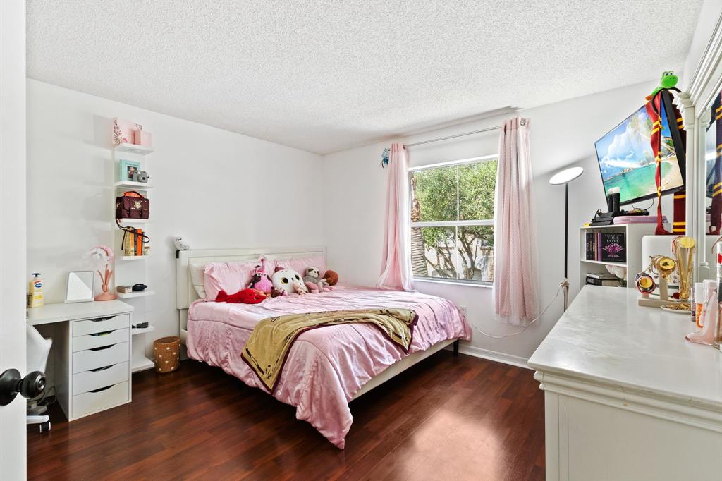 4035 Tree Top Road Cooper City, FL 33026 - Photo 23 of 33 a bedroom with a bed and a wooden floor