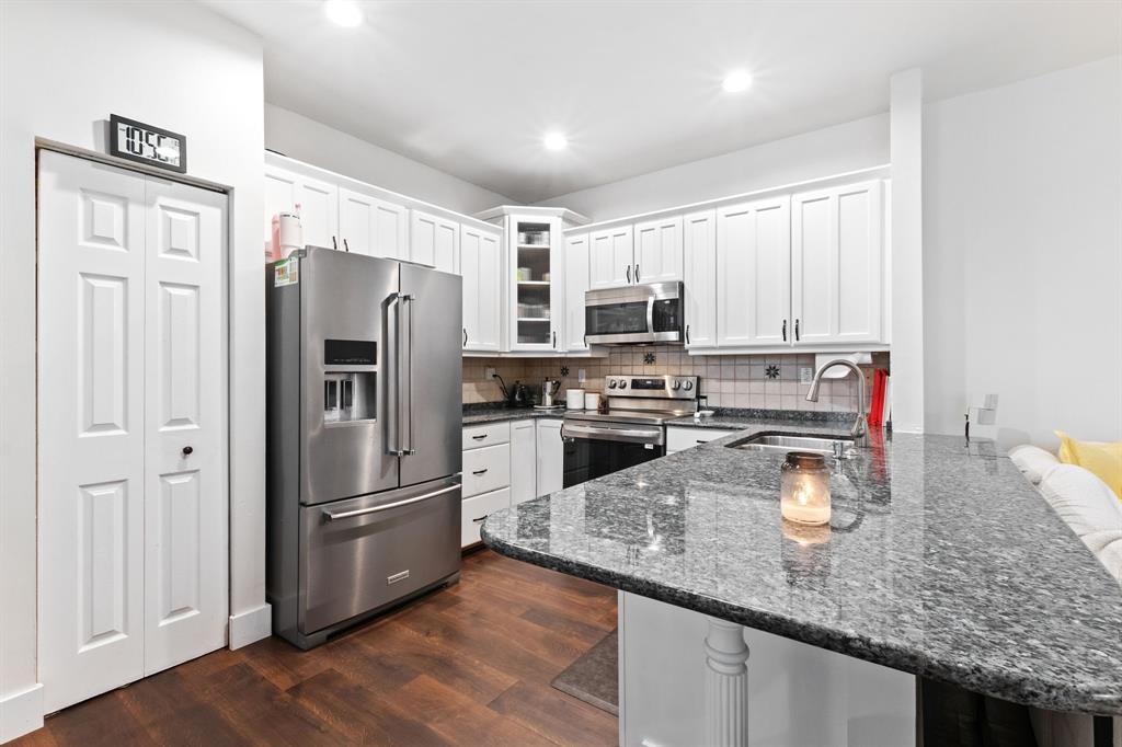 4035 Tree Top Road Cooper City, FL 33026 - Photo 4 of 33 a kitchen with a refrigerator a microwave a sink and white cabinets