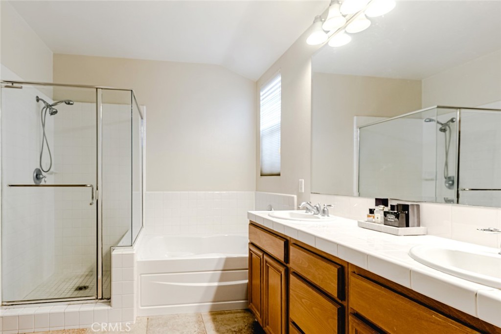 25562 Huxley Drive Stevenson Ranch, CA 91381 - Photo 13 of 24 a bathroom with a sink a shower a mirror and a bathtub