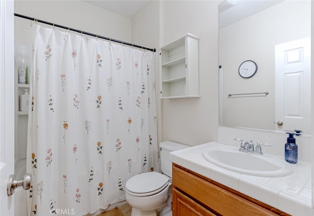 25562 Huxley Drive Stevenson Ranch, CA 91381 - Photo 16 of 24 a bathroom with a granite countertop sink toilet and a mirror