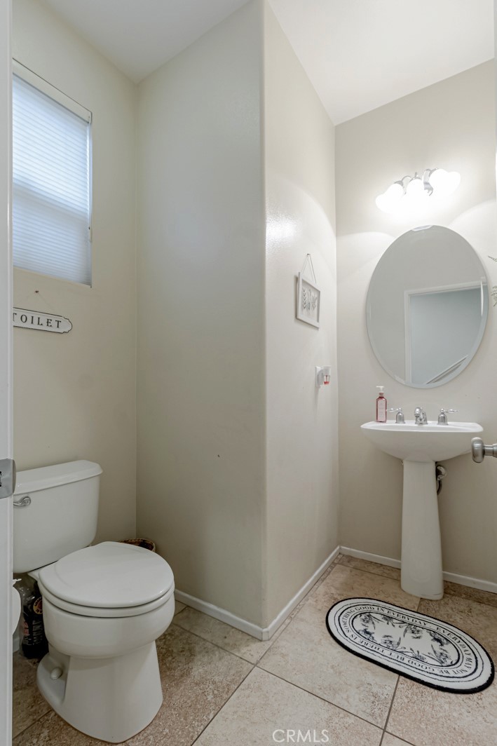 25562 Huxley Drive Stevenson Ranch, CA 91381 - Photo 9 of 24 a bathroom with a toilet a sink and mirror