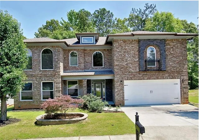 a front view of a house with yard and garage