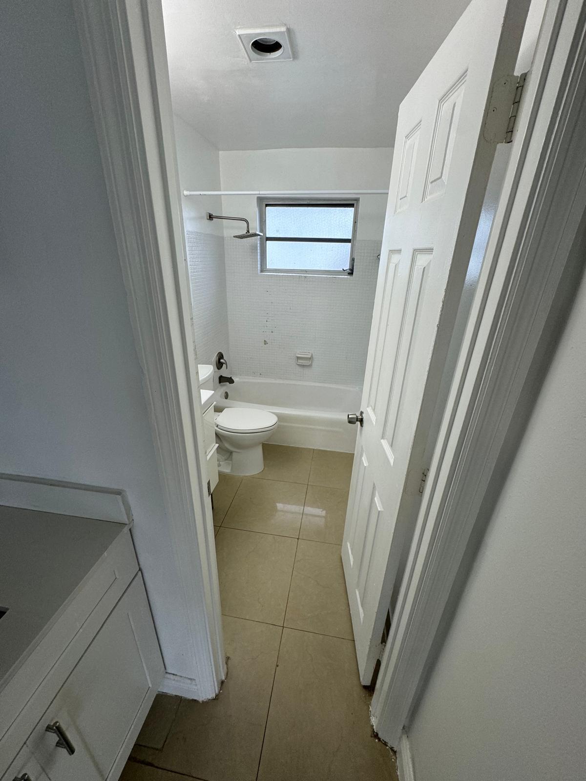 512 Southwest 2nd Street, Unit A Hallandale Beach, FL 33009 - Photo 12 of 13 a bathroom with a sink a toilet and a shower