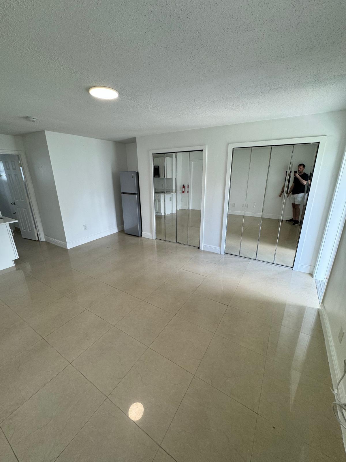 512 Southwest 2nd Street, Unit A Hallandale Beach, FL 33009 - Photo 6 of 13 en empty room with a fireplace and windows