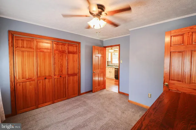 a kitchen with granite countertop a refrigerator a sink and white cabinets