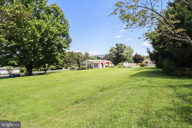 a view of yard from deck with patio
