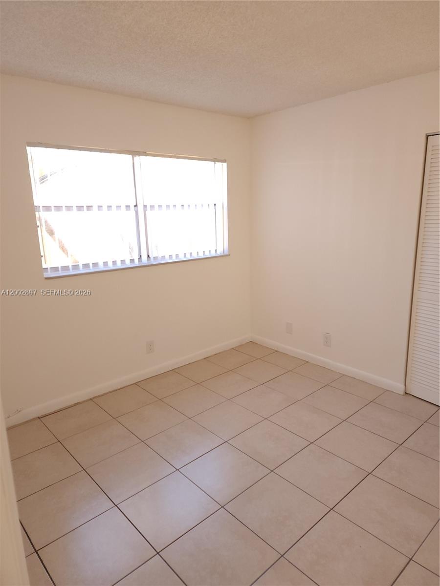4505 Treehouse Lane, Unit 8H Tamarac, FL 33319 - Photo 13 of 29 a view of an empty room and window
