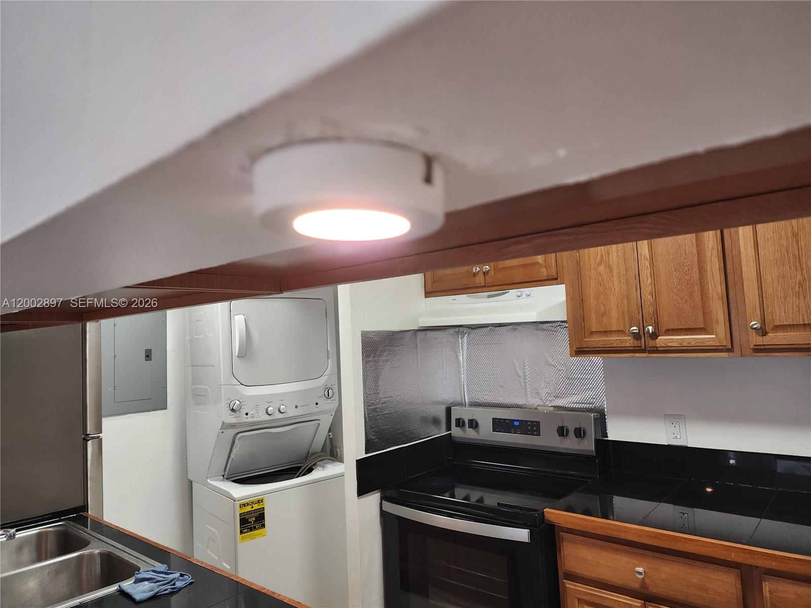 4505 Treehouse Lane, Unit 8H Tamarac, FL 33319 - Photo 25 of 29 a kitchen with a stove and a refrigerator