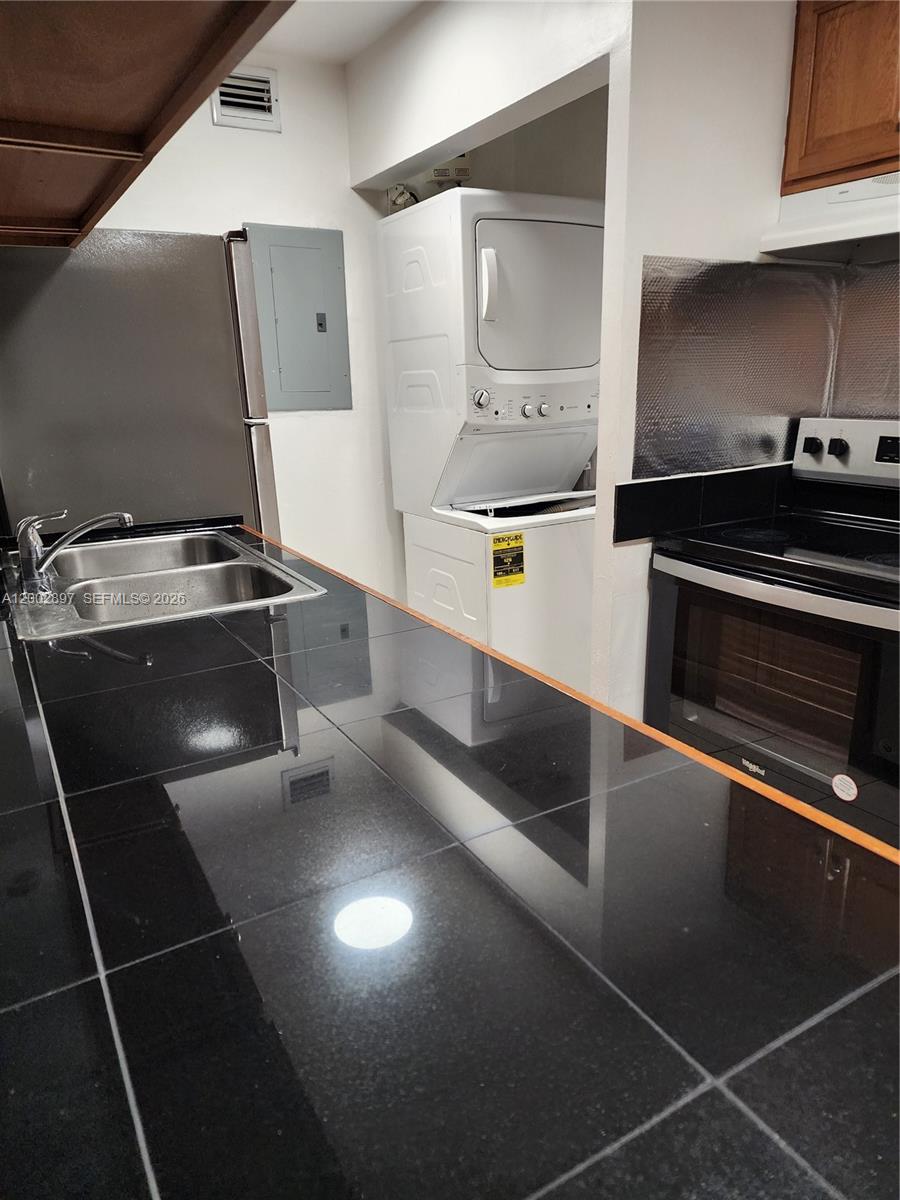 4505 Treehouse Lane, Unit 8H Tamarac, FL 33319 - Photo 29 of 29 a kitchen with granite countertop a stove and a microwave