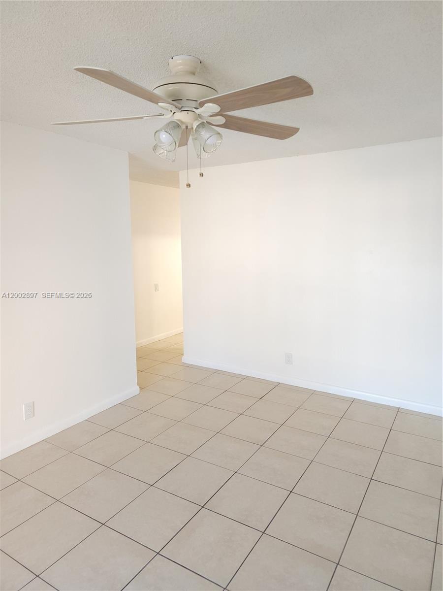 4505 Treehouse Lane, Unit 8H Tamarac, FL 33319 - Photo 4 of 29 an empty room with a chandelier fan