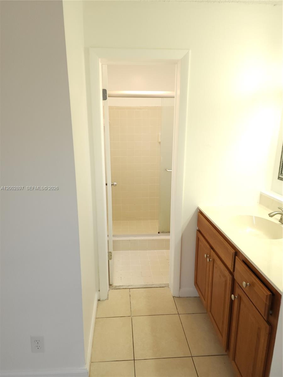 4505 Treehouse Lane, Unit 8H Tamarac, FL 33319 - Photo 7 of 29 a bathroom with a granite countertop sink a mirror and a bathtub