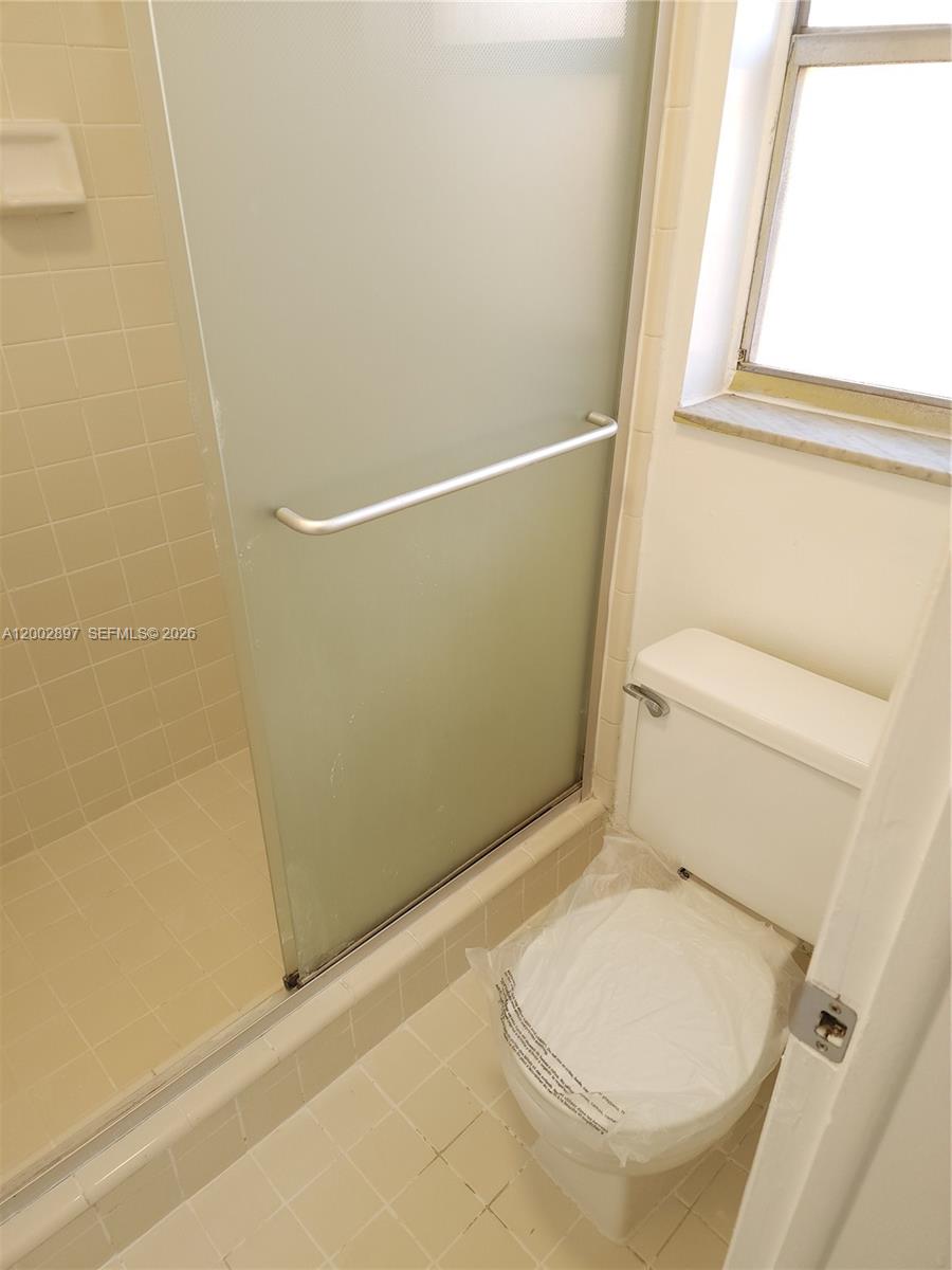 4505 Treehouse Lane, Unit 8H Tamarac, FL 33319 - Photo 9 of 29 a bathroom with a toilet and a shower