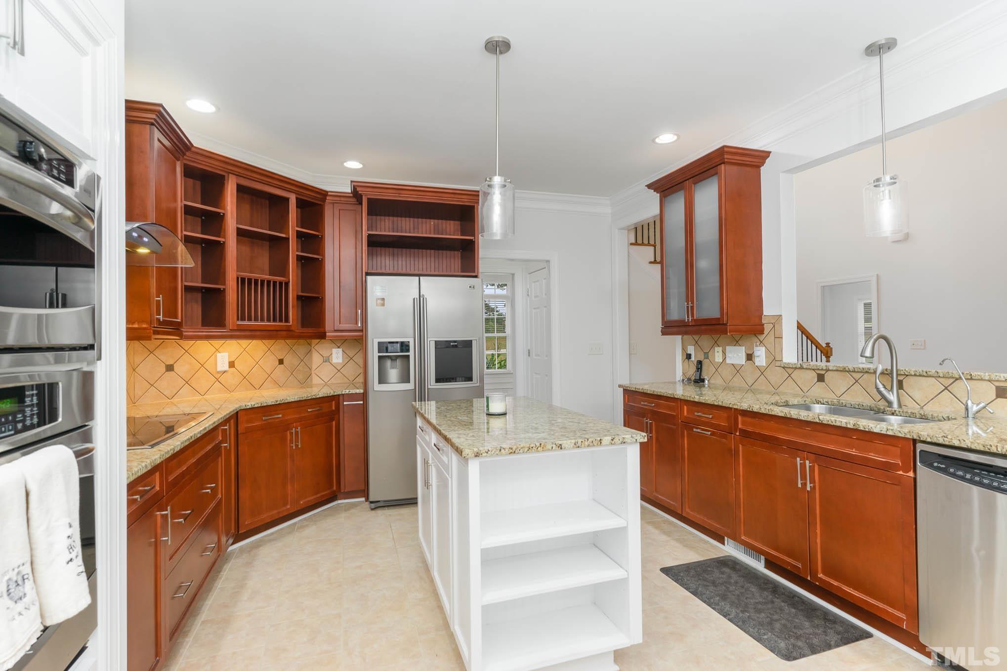 320 Government Road Clayton, NC 27520 - Photo 15 of 48 a large kitchen with stainless steel appliances granite countertop a sink and cabinets
