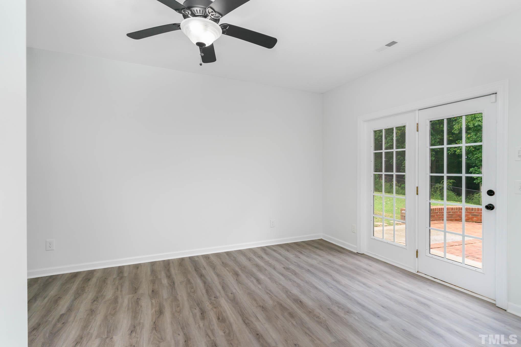 320 Government Road Clayton, NC 27520 - Photo 31 of 48 an empty room with wooden floor fan and windows