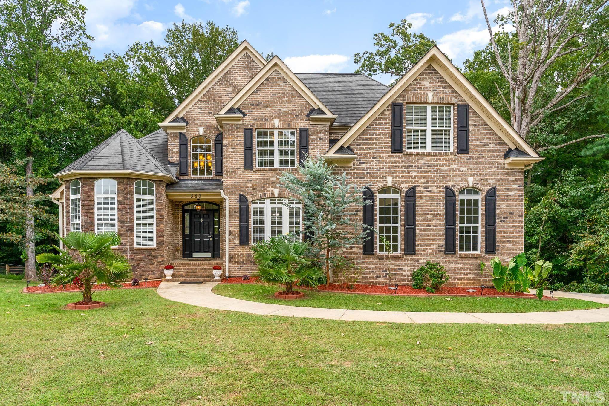 320 Government Road Clayton, NC 27520 - Photo 4 of 48 a front view of a house with a yard and porch